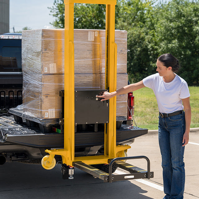 Woman operating Machenburg pallet lifter using electric controls for one-person loading