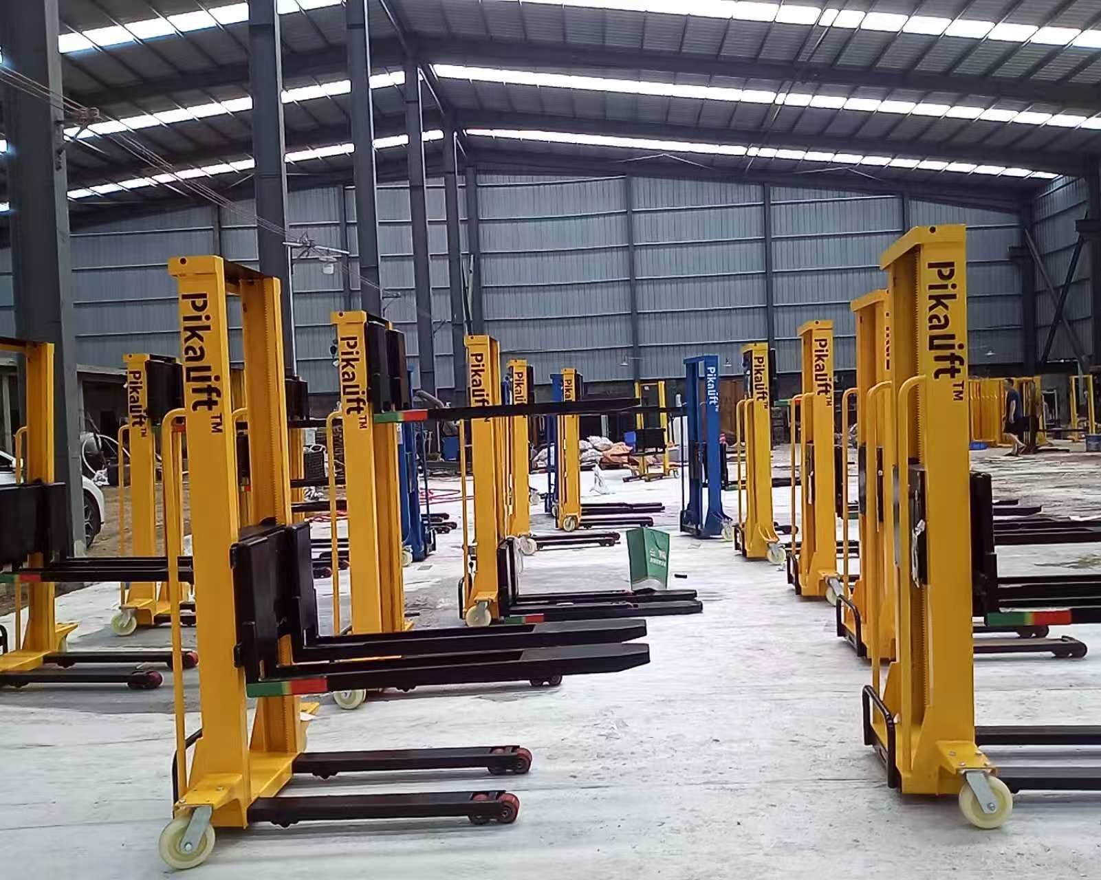 Row of yellow Pikalift stacker cranes in a warehouse setting