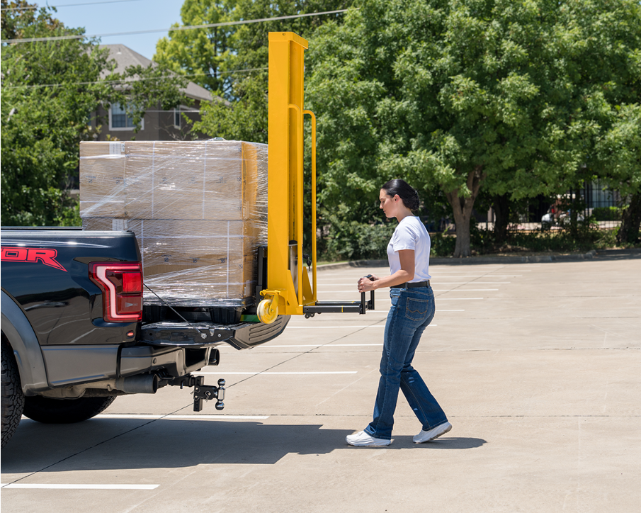Woman operating Machenburg pallet lifter to load pallet onto pickup truck